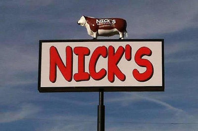 Nick's roadside sign topped by a cow statue