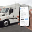 XPO Connect on a smart phone being held up in front of an XPO Logistics semi-truck
