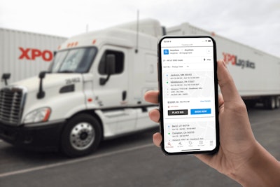 XPO Connect on a smart phone being held up in front of an XPO Logistics semi-truck