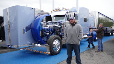 austin kiser standing in front of a semi-truck