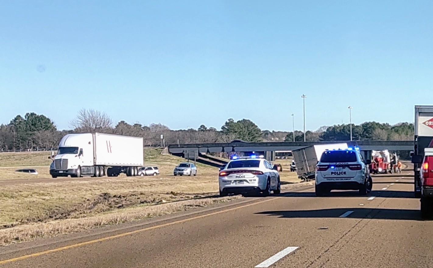 Semi-truck crash with police cars on a highway