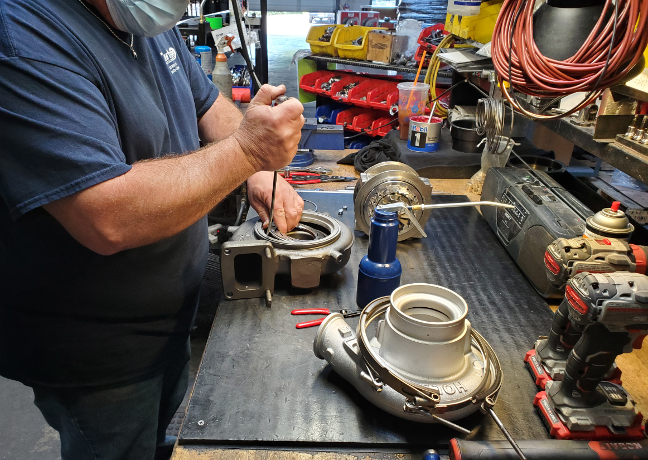Someone works on remanufacturing a turbocharger.