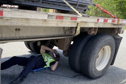 inspector checking trailer brakes