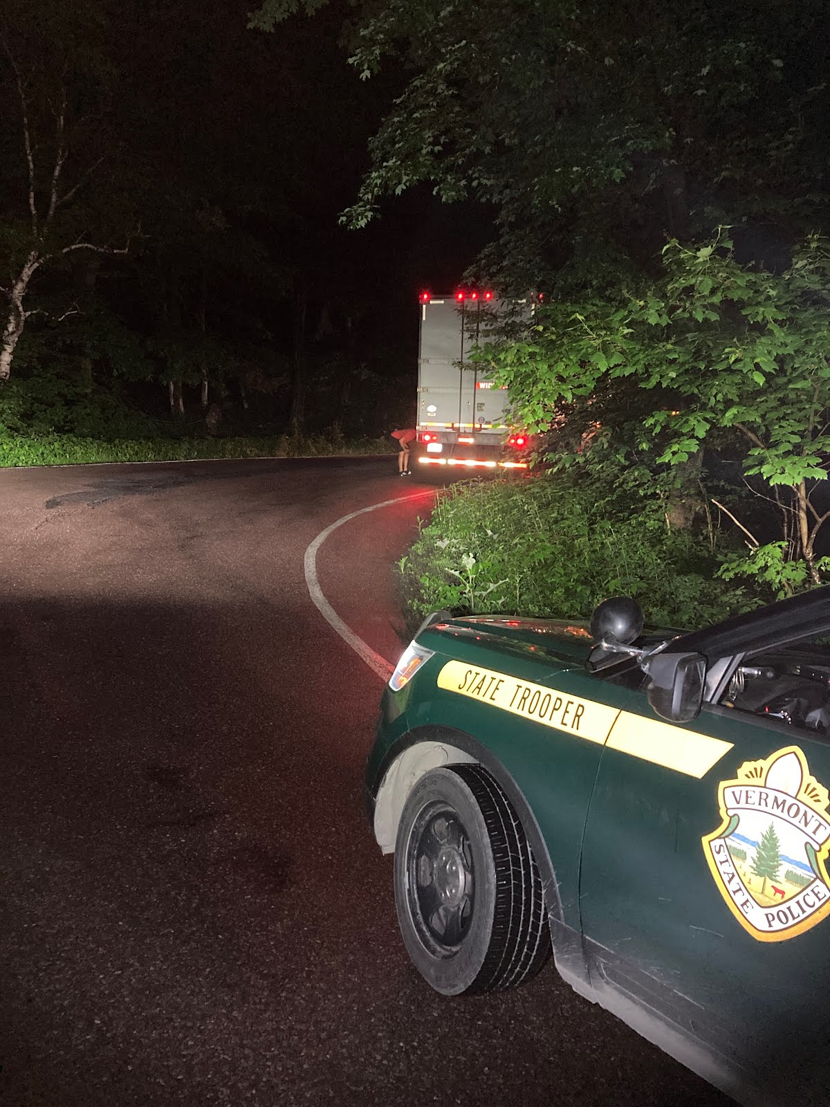 Vermont State Police vehicle parked behind the stuck semi-truck on smuggler's notch