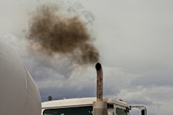 A cloud of dark exhaust floats from a truck exhaust pipe.