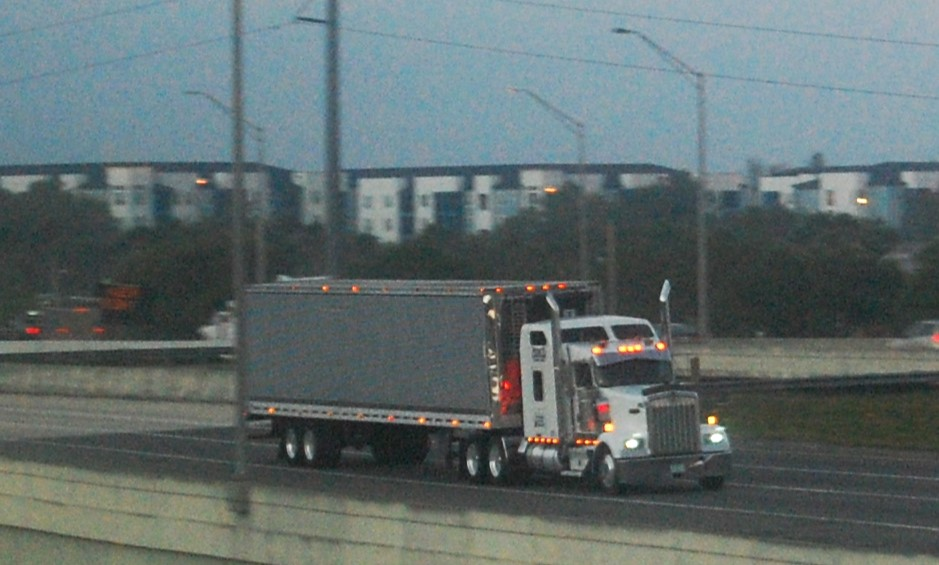 Kenworth truck pulling dry van trailer on a highway