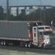 Kenworth truck pulling dry van trailer on a highway