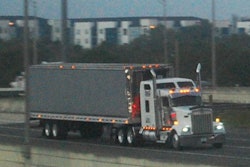 Kenworth truck pulling dry van trailer on a highway