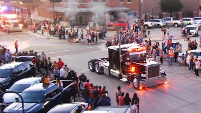 Owner-operator Crispell's 359 here is shown at the start of its lap around then Denton courthouse square. During the procession, each individual rig and its owner were saluted by Peterbilt Senior Project Engineer and event master of ceremonies Jan Langelius, speaking from the LSA Burger Co. rooftop deck overlooking the square.