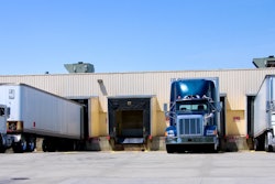 Three trucks back to a dock