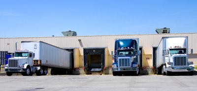 Three trucks back to a dock