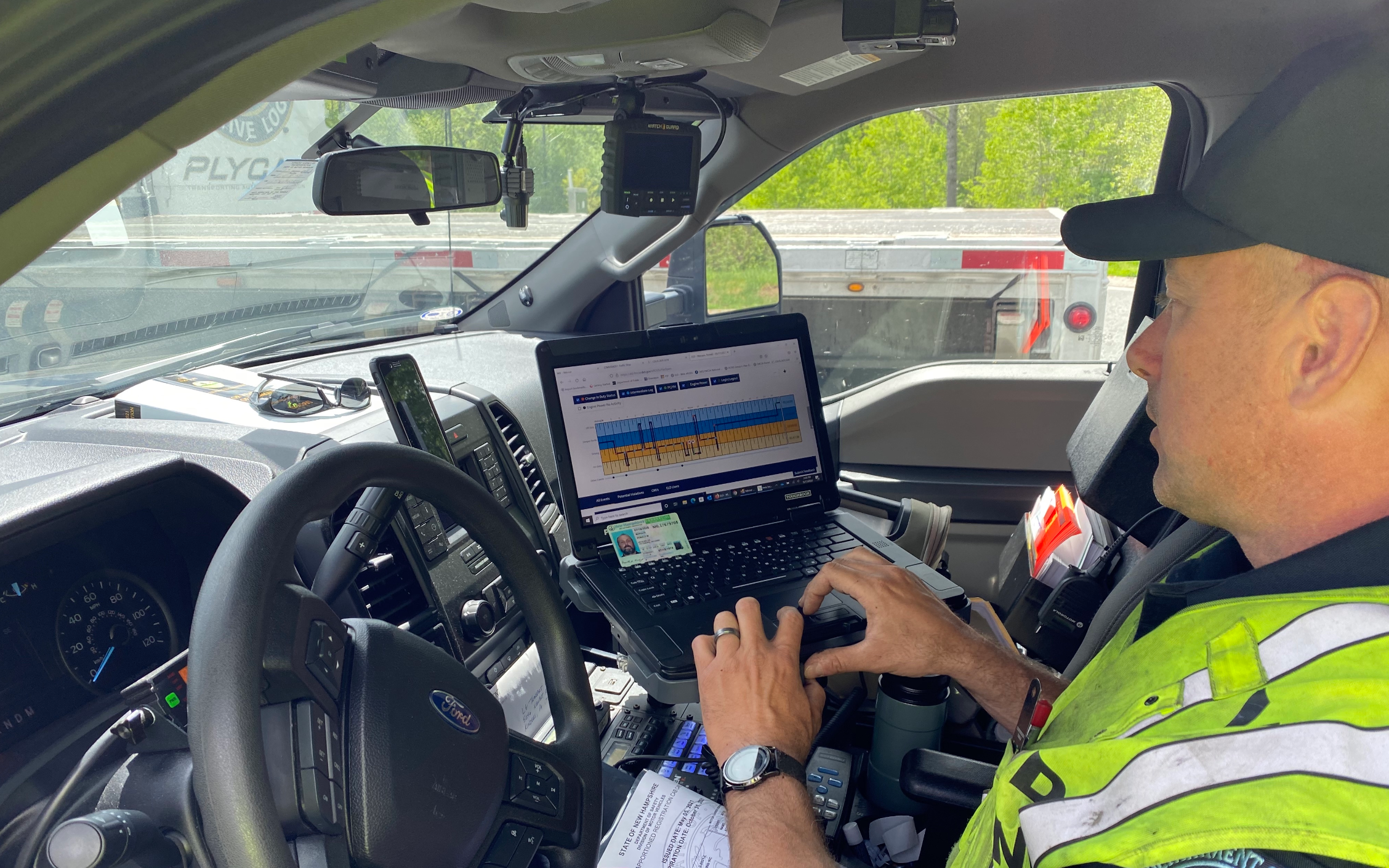 DOT officer checking truck driver's logs