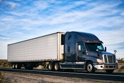 Freightliner Cascadia on a highway with clouds behind