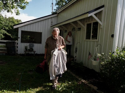Paul Marhoefer leaving home, Denise Marhoefer and house in background