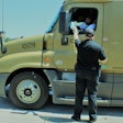 Officer handing truck driver paperwork