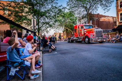 kenworth w900l with spectators watching parade from both sides of the street