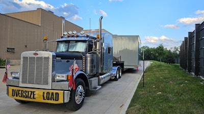 The Schmitts' truck hauling an oversize load, caught between a rock and a hard place as state permitting websites fall to the massive outage.