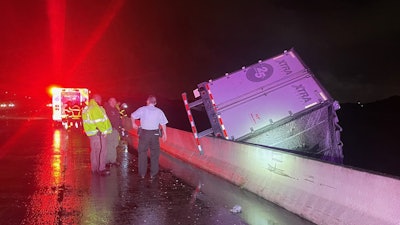 This picture from the scene shows the truck dangling from the causeway.