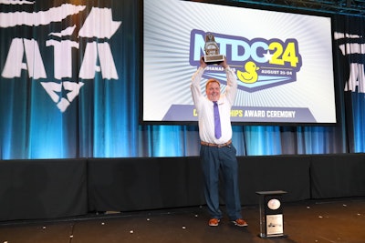 Jackie Reed holding the Bendix Grand Championship Trophy above his head