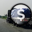Flatbed on highway with magnifying glass, dollar sign