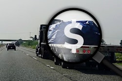 Flatbed on highway with magnifying glass, dollar sign