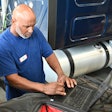 Mechanics using a computer to diagnose a truck problem