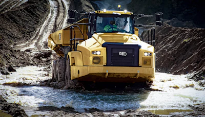 front of cat 745 articulated dump truck running through mud puddle