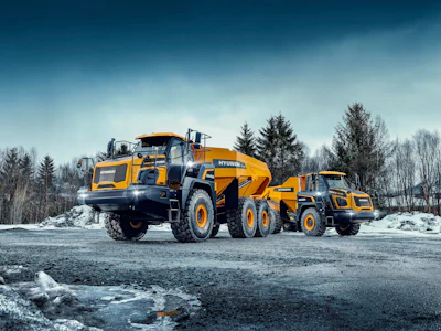 Hyundai HA30 and HA45 dump trucks on asphalt road in snow