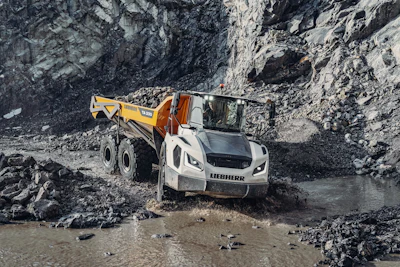 Liebherr TA230 dump truck at bottom of quarry crossing water