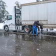 trucker putting chains on truck