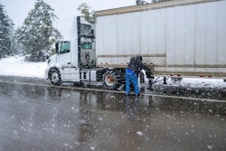 trucker putting chains on truck