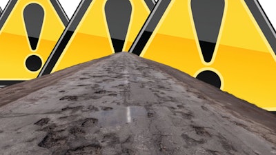 Pot-holed road and alert triangles.