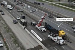 This aerial view of the crash site on I-35 shows the tractor-trailer at its final rest position. Other crash-involved vehicles can be seen within the roadway behind the combination vehicle.