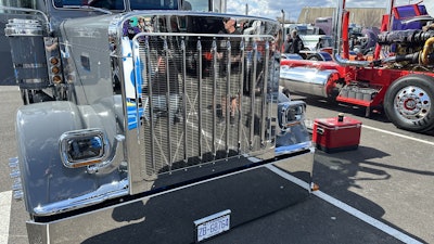 The truck features numerous custom parts, including a 379-style grille shell with JJ brackets that were chromed to match the stainless on the truck. The headlights were shaved on the sides and bottoms. It also features a stainless lift bumper.