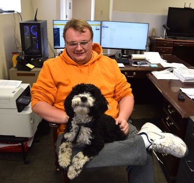 Steve Wilson the second, increasingly taking an operations and safety role in the business, is pictured here with the office mascot, one Tilley, smiling for the camera.