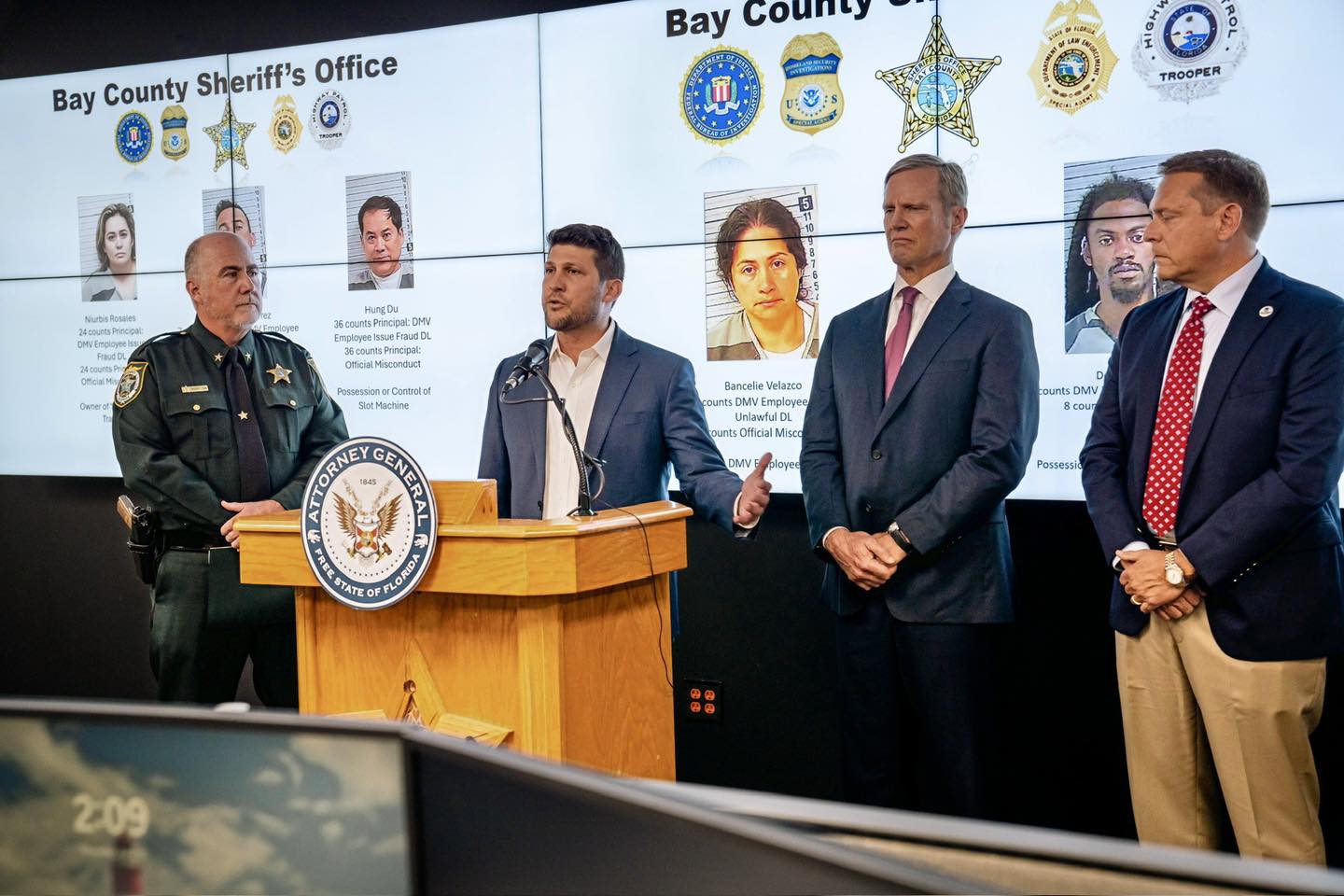 Florida Attorney General James Uthmeier (podium) and Bay County Sheriff Tom Ford (left) present the results of an investigation into a cash-for-credentials scheme in Florida.
