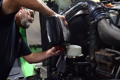 Another needed repair? The power steering reservoir was 'leaking like a sieve,' Rissler said, with some corrosion. The day before the Crossroads show, he took delivery of a replacement from Peterbilt and is shown filling the system in the Detroit-powered unit. It's got a 13-speed transmission and 3.55 rears.