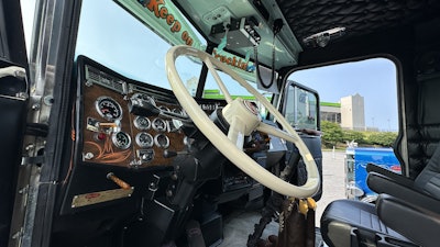 The interior is black leather with ostrich upholstery. The original dash remains, with added pinstriping to match the rig's exterior.