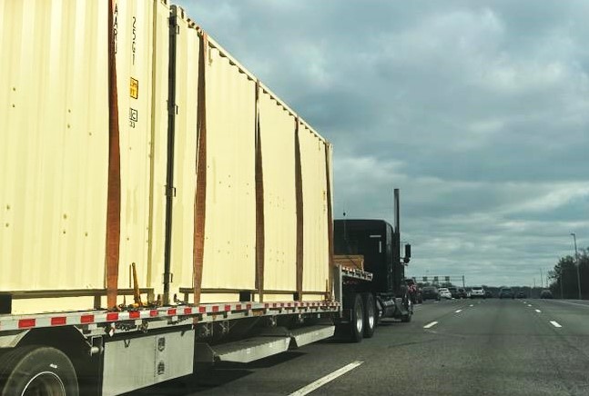 Step Deck Loaded With Storage Containers On Highway