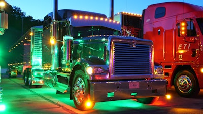 The truck features plenty additional lights, including green underglow to complement the dark green paint on the rig, along with light bars on the back of the tractor.