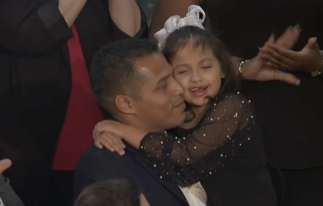 Marcus Coleman holding his daughter, Dalilah, at the 2026 State of the Union address.