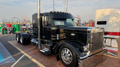 Cody McCandless, with Geis Peterbilt, is showing his latest creation, which he built for Josh Baker and Paige Roberts over the course of just 90 days. The 2025 Peterbilt 589 features plenty custom touches, including 'ghost stripes' that show up in the sunlight.