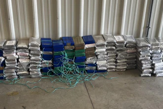 Inside the rear of the trailer, several duffle bags and cardboard boxes were found, containing approximately 392 pounds of suspected cocaine.