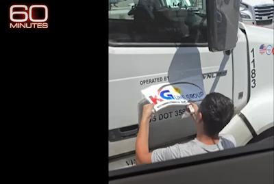 Still from the 60 Minutes broadcast, showing the change of company names on the door.