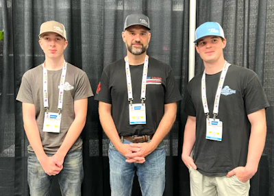 Mark Yelton (center) with sons Will (left) and Sam at MATS. Yelton predicts as many as three of his sons could eventually follow him into trucking.