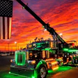 The truck itself doesn't feature patriotic graphics, but owner Clifton Parsley's 'Heavy Hook' 2024 Peterbilt 389 tow truck can be seen at various truck shows throughout the year hoisting Old Glory high above the parking lot.