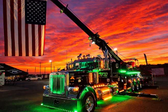 The truck itself doesn't feature patriotic graphics, but owner Clifton Parsley's 'Heavy Hook' 2024 Peterbilt 389 tow truck can be seen at various truck shows throughout the year hoisting Old Glory high above the parking lot.