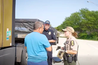 'You're picking up in Wyoming? I thought you just said South Dakota?' FMCSA Administrator Derek Barrs looks on as an inspector grills a driver during the second wave of Operation Highway Shield.
