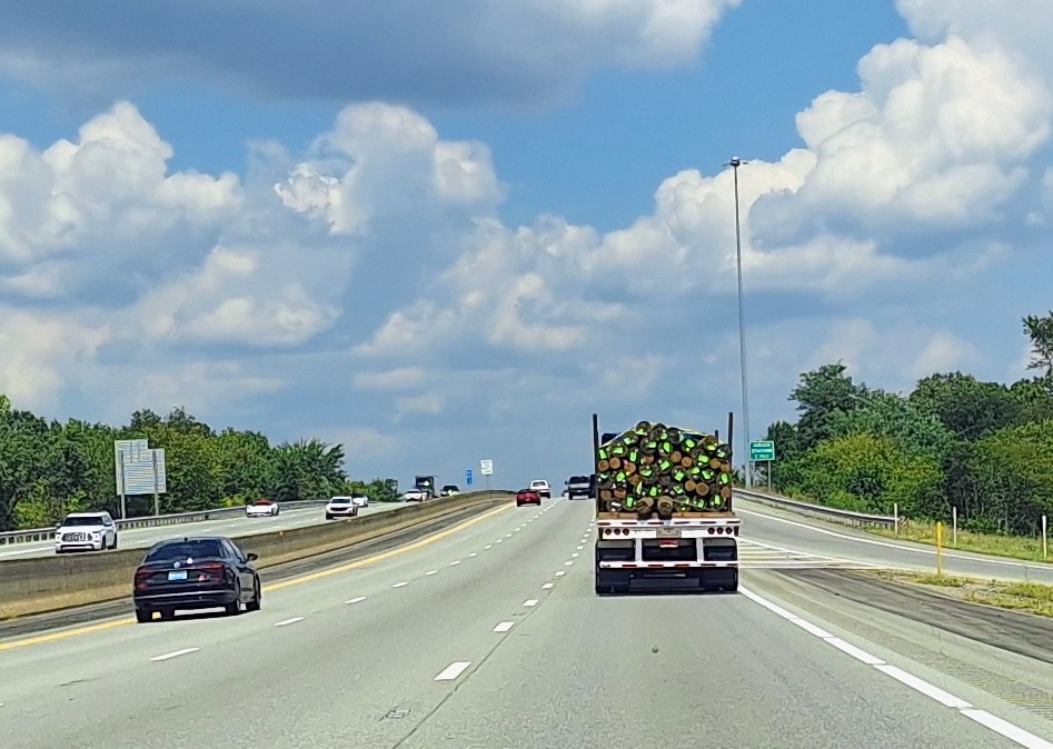 Flatbed With=poles Wood On Highway