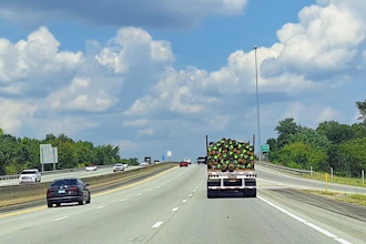 Flatbed With=poles Wood On Highway